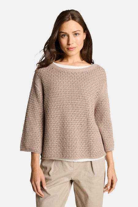Taupe trui van Tom Tailor in textuurgebreid met driekwartmouwen, achterzijde op een beige broek.