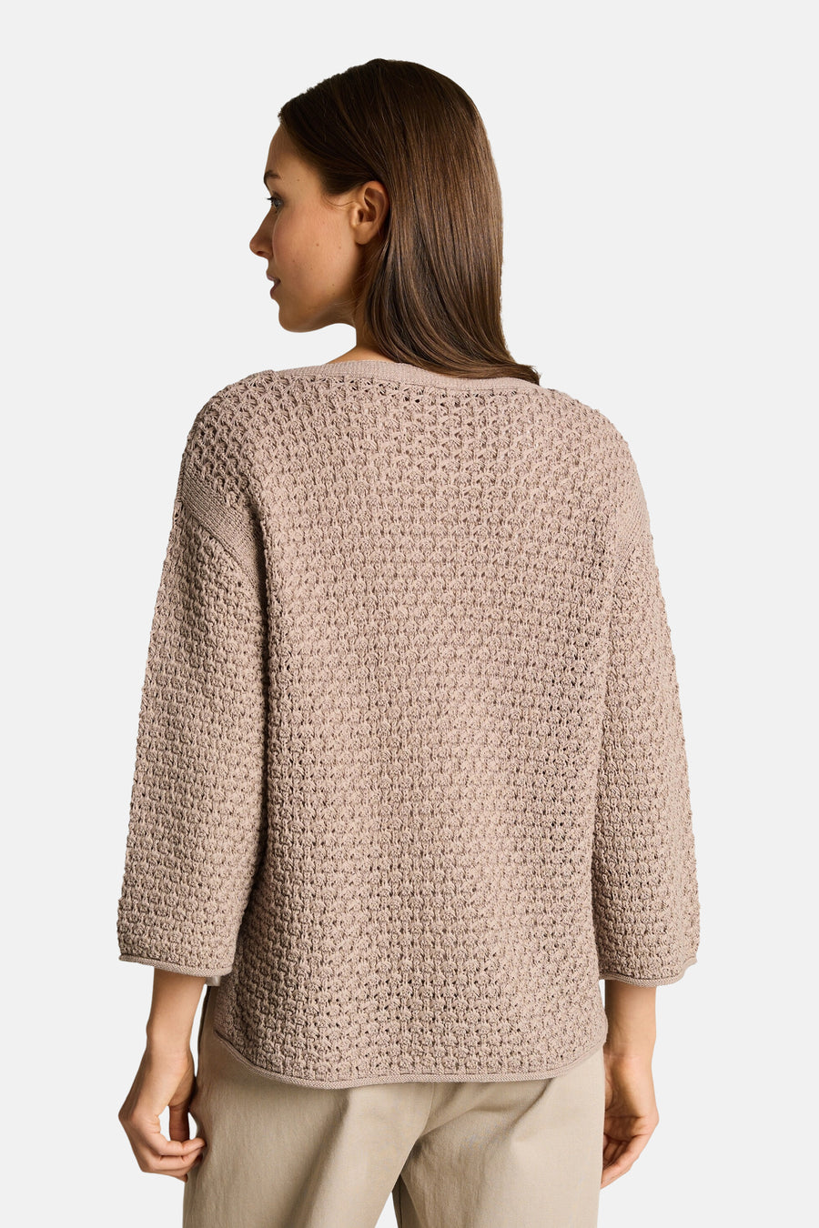 Pull taupe de Tom Tailor en maille texturée avec manches trois-quarts, vue de dos sur un pantalon beige.