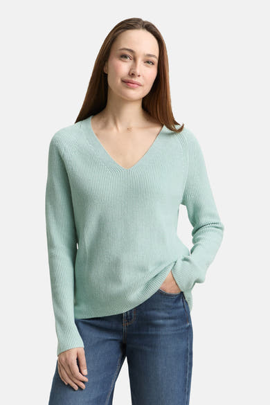 Tom Tailor V-hals trui groen, met een ribbelstructuur en lange mouwen, gedragen met een blauwe jeans.