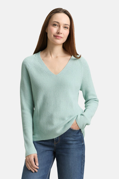 Pull à col en V vert de Tom Tailor, avec un tricot côtelé, porté avec un jean décontracté.
