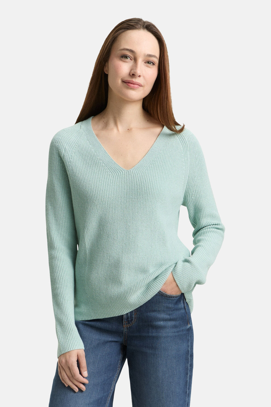 Tom Tailor V-hals trui groen, met een ribbelstructuur en lange mouwen, gedragen met een blauwe jeans.