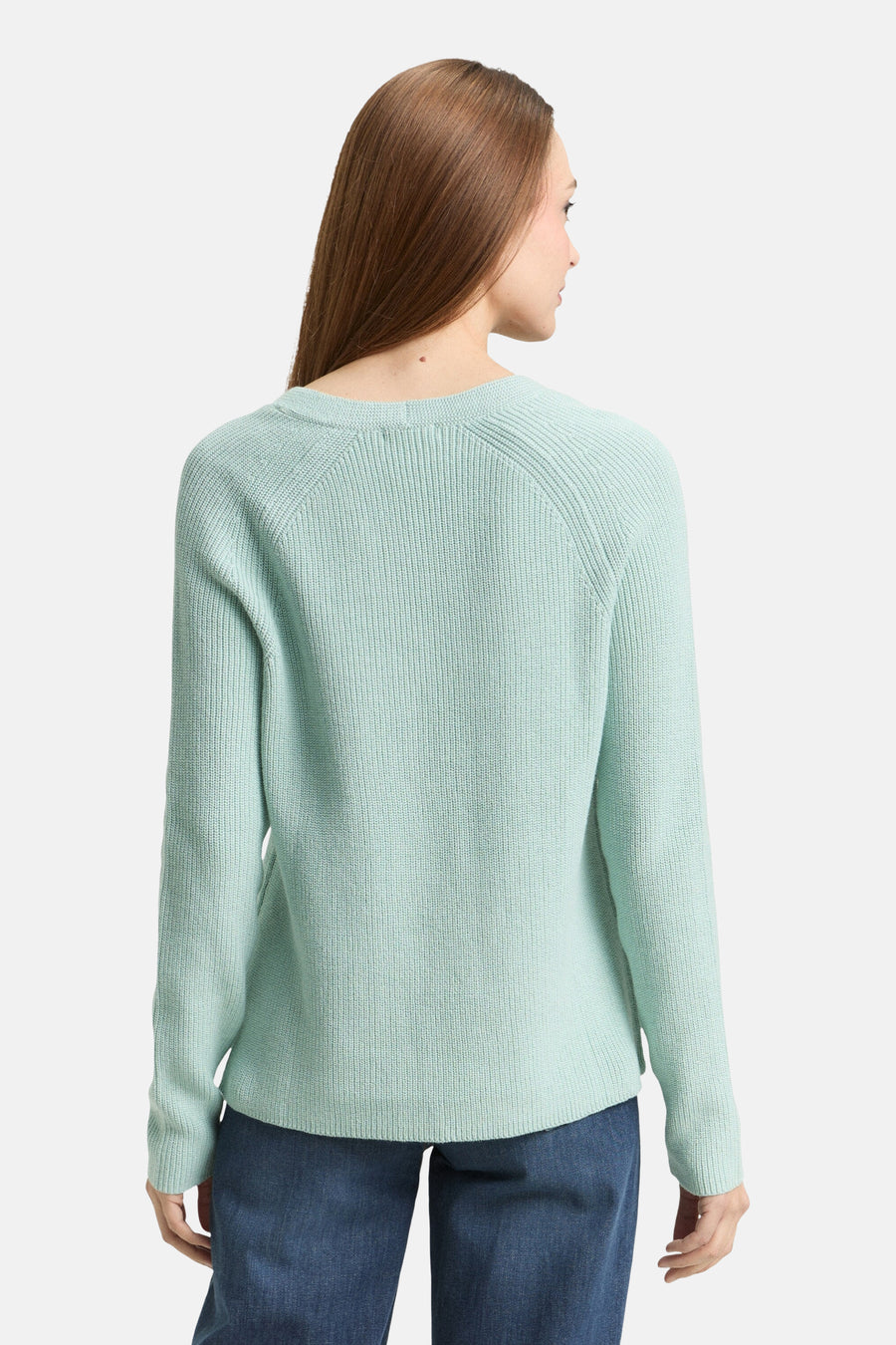 Pull col V vert de Tom Tailor, avec une texture côtelée et des manches longues, porté avec un jean bleu.
