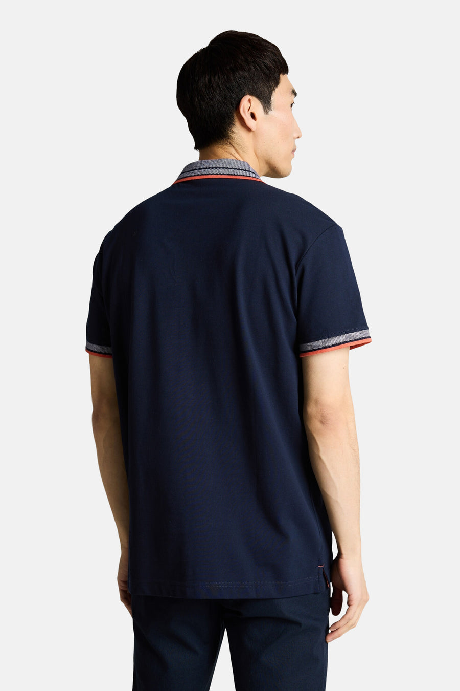 Donkerblauwe polo van Tom Tailor, achterzijde, met kraag en manchetten met textuurrand en oranje bies.