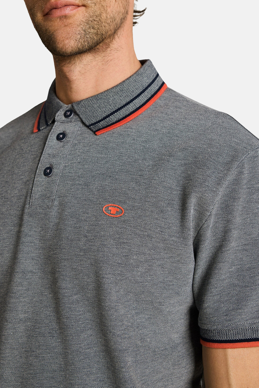 Polo gris chiné de Tom Tailor avec col et poignets rayés, logo orange.