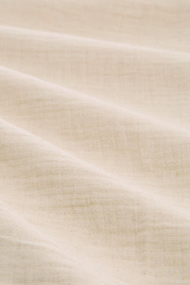 Beige broek van Tom Tailor, close-up van de getextureerde stof met zachte plooien.