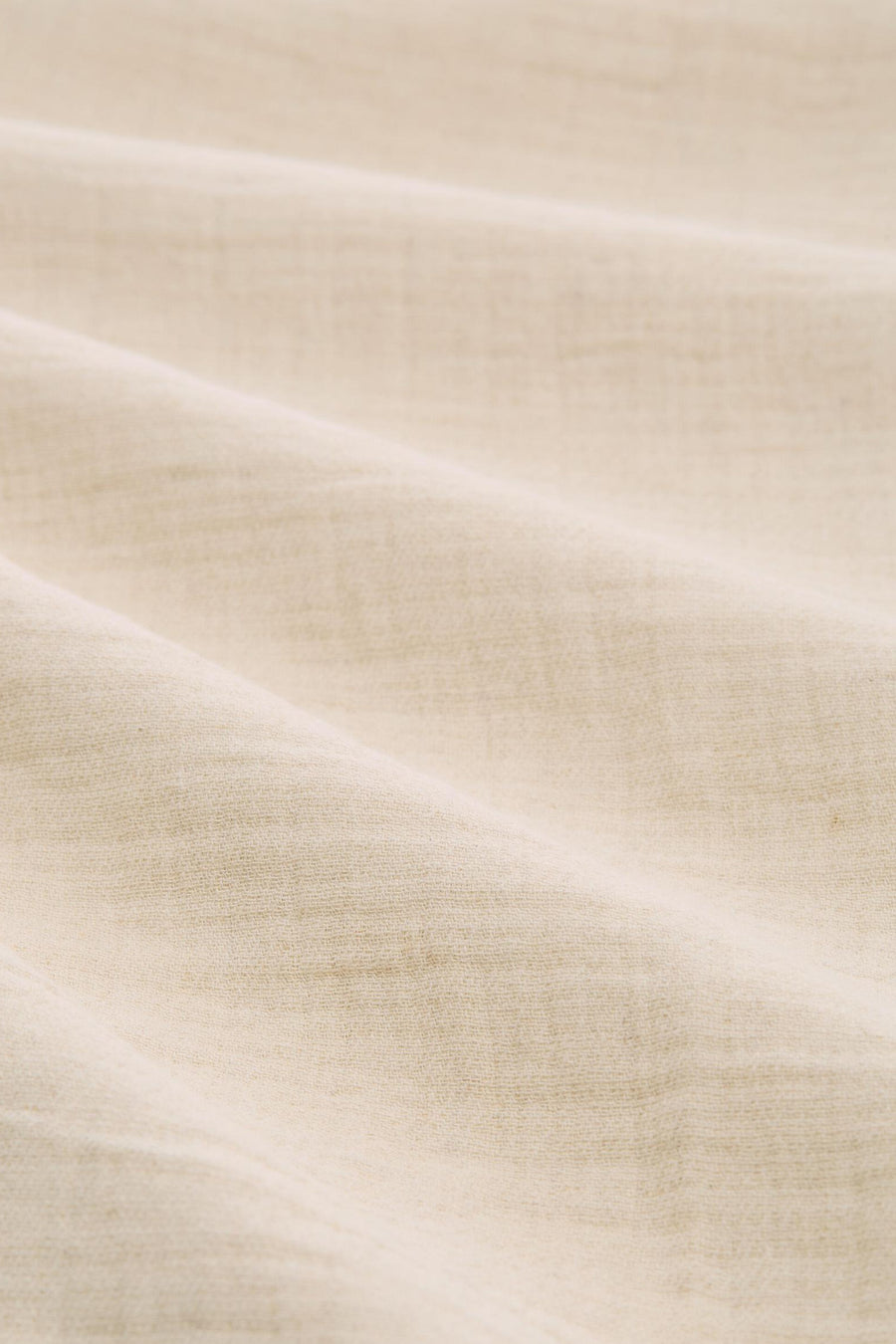 Beige broek van Tom Tailor, close-up van de getextureerde stof met zachte plooien.