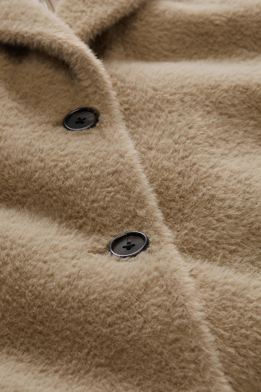 Taupe fuzzy poncho with black buttons, close-up front view showing soft texture and plush material