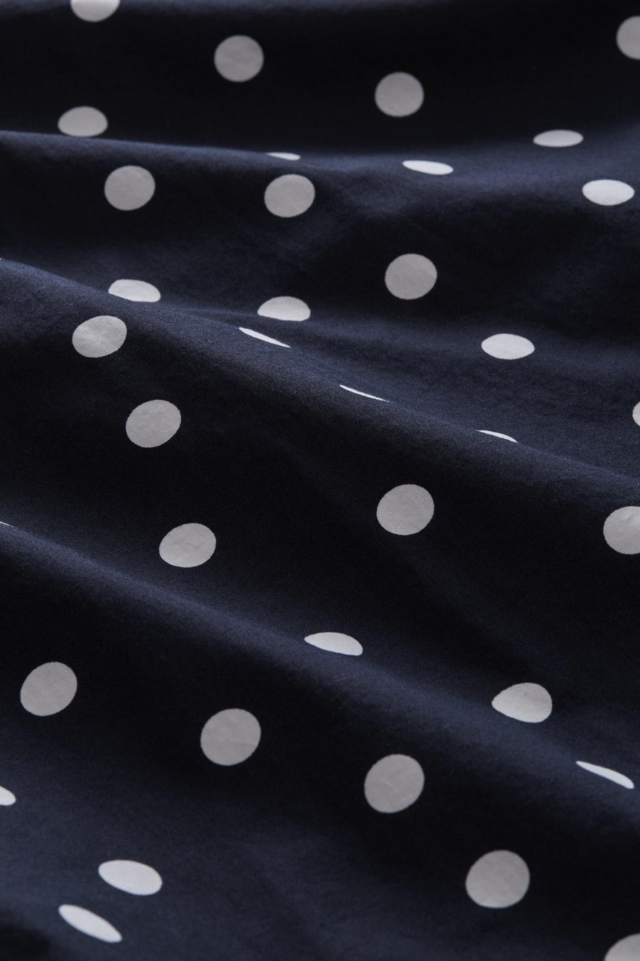 Navy blue short-sleeve blouse with white polka dots by Tom Tailor, close-up fabric texture view