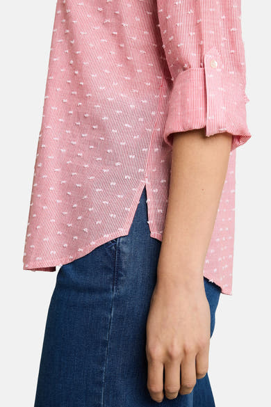 Pink long-sleeve blouse with white dotted pattern by Tom Tailor, rolled cuffs, worn with blue jeans, side view