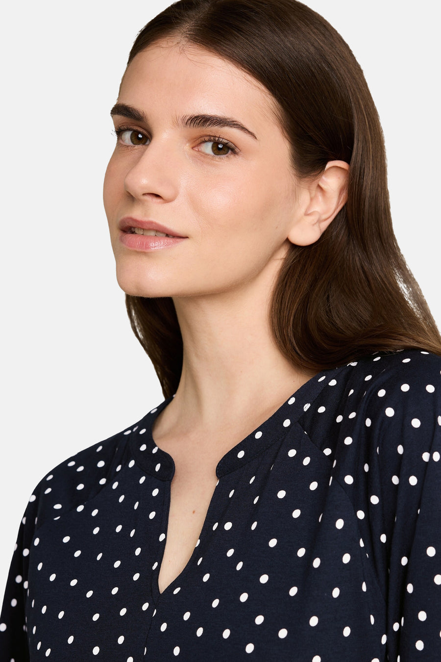 Multicolored 3/4-sleeve blouse with navy base and white polka dots, V-neckline, side view close-up