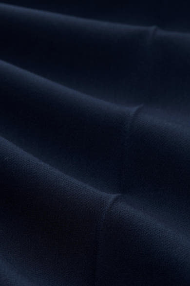 Navy blue suit trousers by Tom Tailor, close-up view showcasing smooth textured fabric with soft folds and rich color depth.