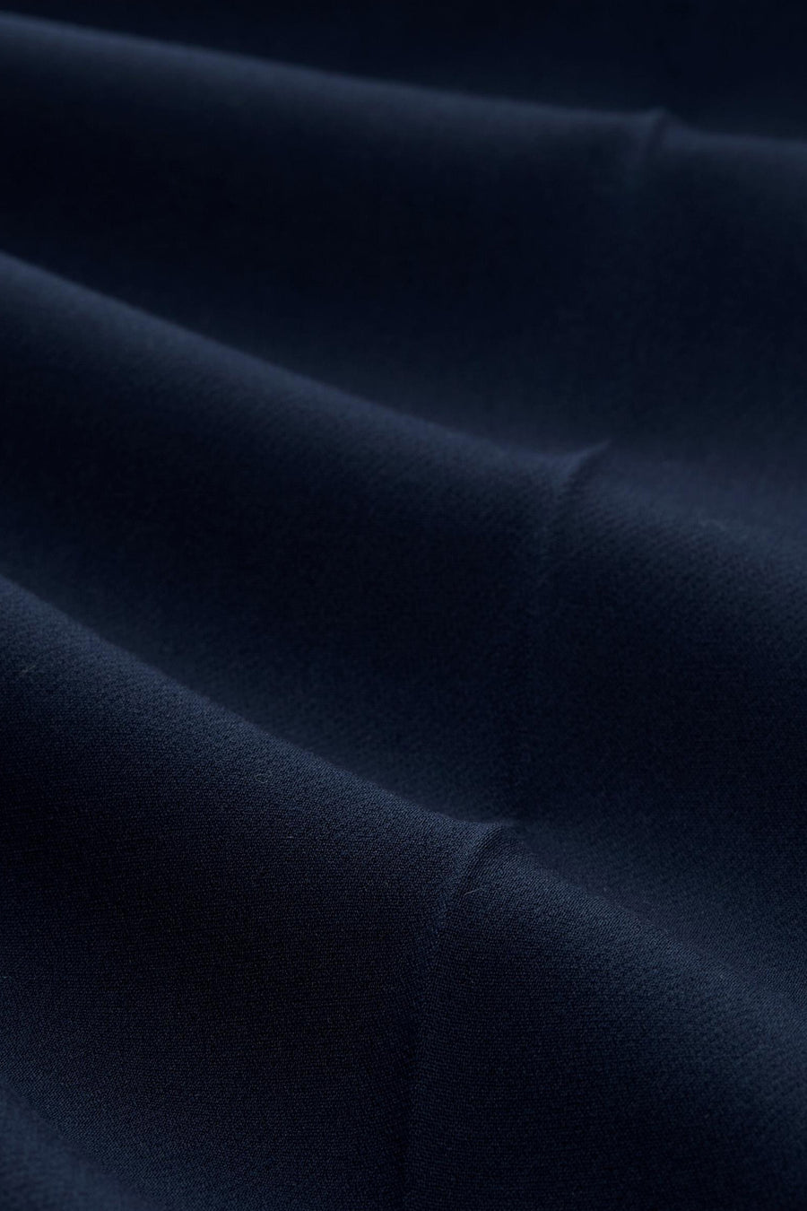 Navy blue suit trousers by Tom Tailor, close-up view showcasing smooth textured fabric with soft folds and rich color depth.