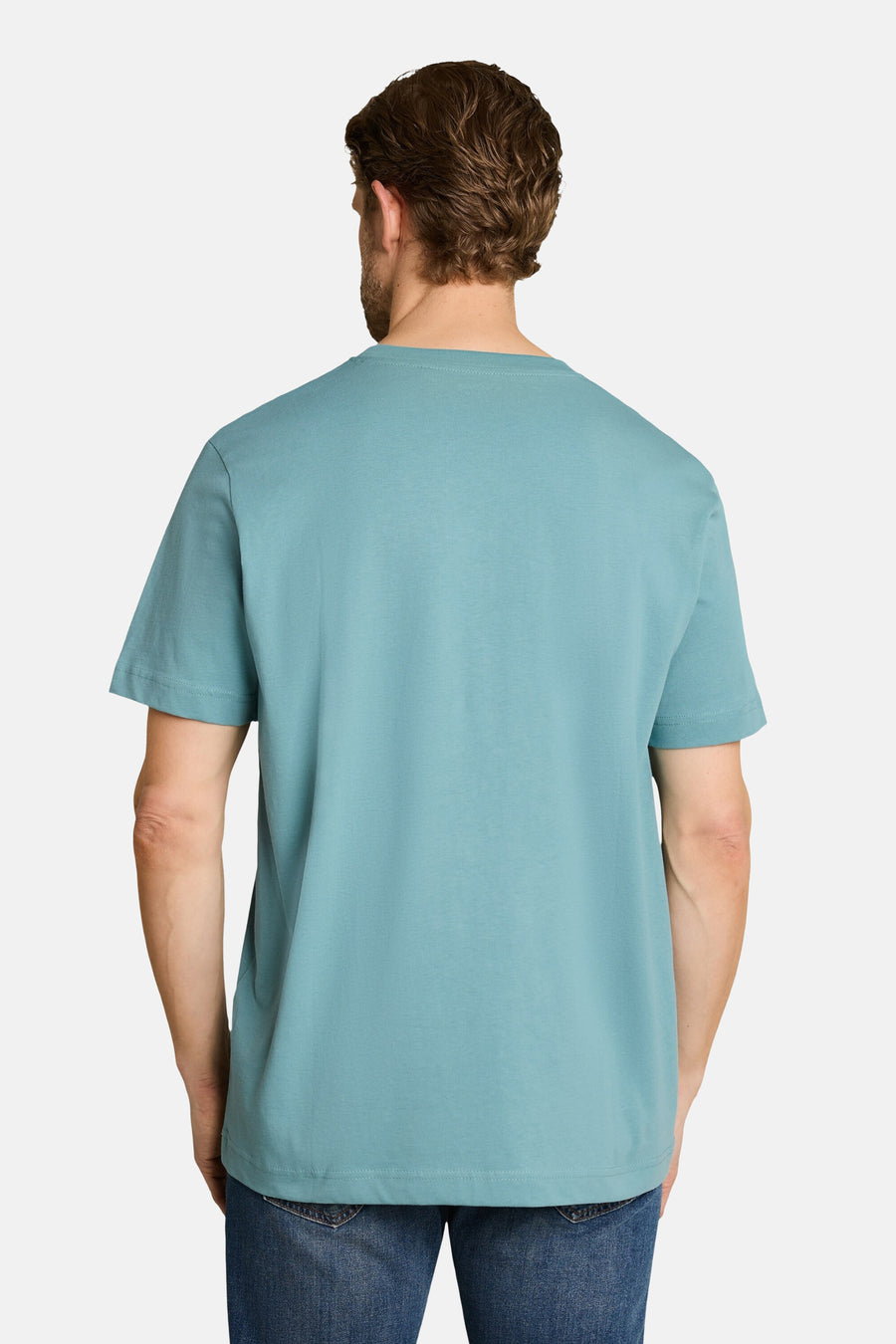 Blue short-sleeve t-shirt back view, solid color, soft cotton texture, worn with dark jeans