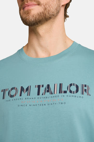 Teal short-sleeve T-shirt by Tom Tailor with bold striped logo print and text details, shown in close-up front view