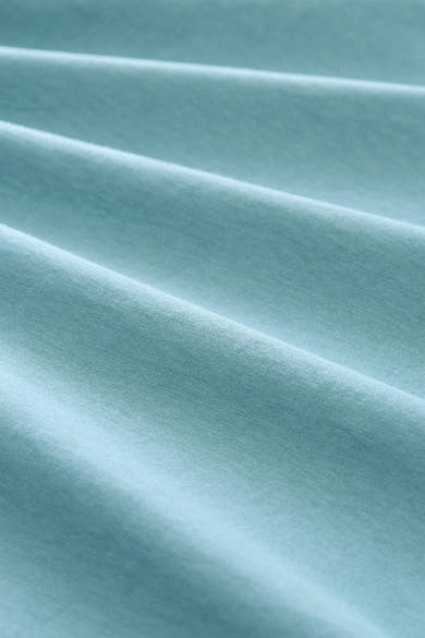 Blue short-sleeve t-shirt fabric close-up, soft textured knit with gentle folds and smooth finish.