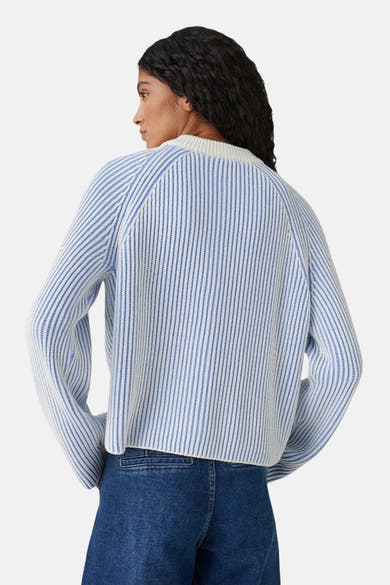 Cardigan bleu rayé par OPUS, en maille fine, vu de dos et porté avec un pantalon en jean.