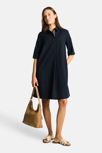 Robe chemise bleu marine de Tom Tailor à col classique et manches 3/4, portée avec un sac et des sandales beiges.