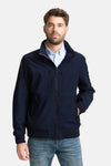Korte blauwe jas van Tom Tailor, gedragen met een gestreept overhemd en een spijkerbroek, witte schoenen.