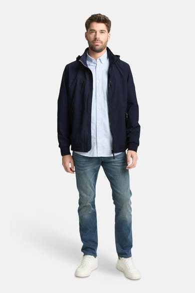Veste courte bleue de Tom Tailor, portée avec une chemise rayée et un jean, chaussures blanches.