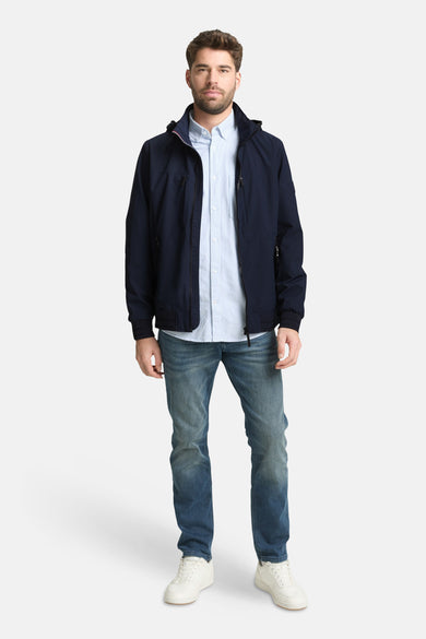 Veste courte bleue de Tom Tailor, portée avec une chemise rayée et un jean, chaussures blanches.