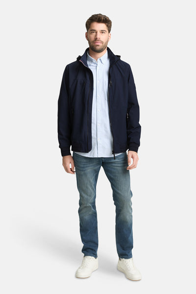 Veste courte bleue de Tom Tailor, portée avec une chemise rayée et un jean, chaussures blanches.