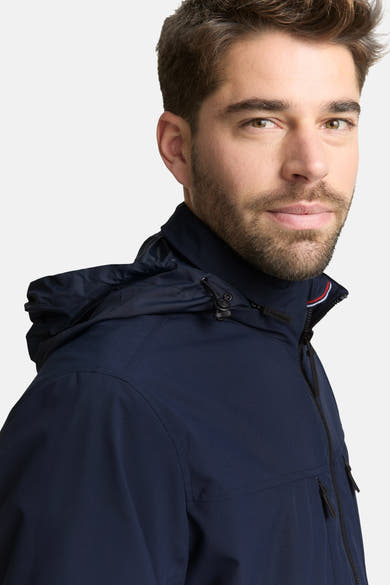 Korte blauwe jas van Tom Tailor, met capuchon en zwarte ritssluiting.