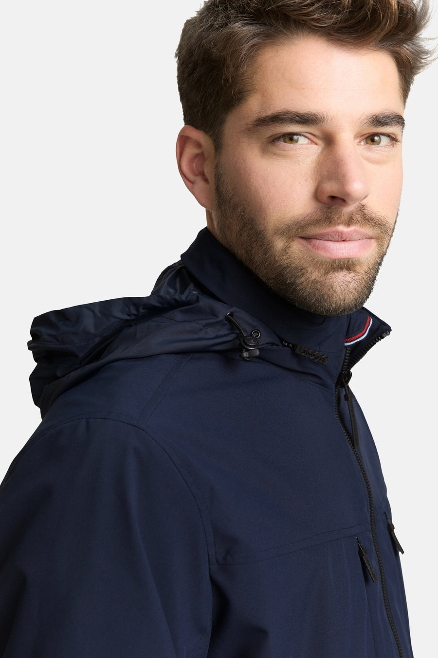 Korte blauwe jas van Tom Tailor, met capuchon en zwarte ritssluiting.