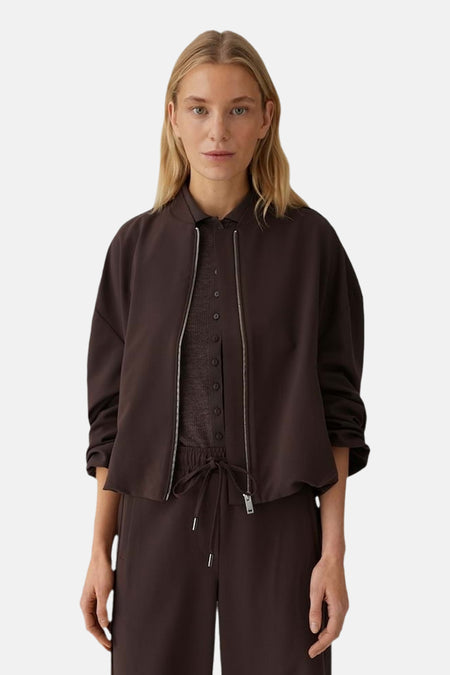 Veste courte brune d'OPUS, avec fermeture éclair argentée sur chemisier et pantalon assortis.