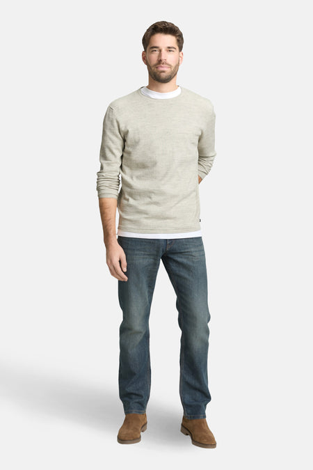 Pull à col rond gris par Tom Tailor, porté avec un jean bleu et des bottines marron.