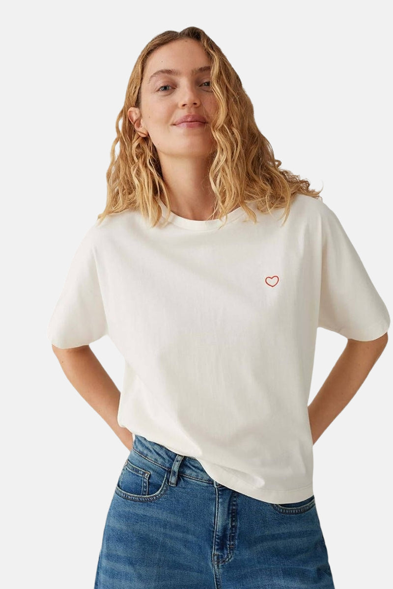 Top uni manches courtes beige d'OPUS, avec un petit cœur rouge brodé sur le devant.
