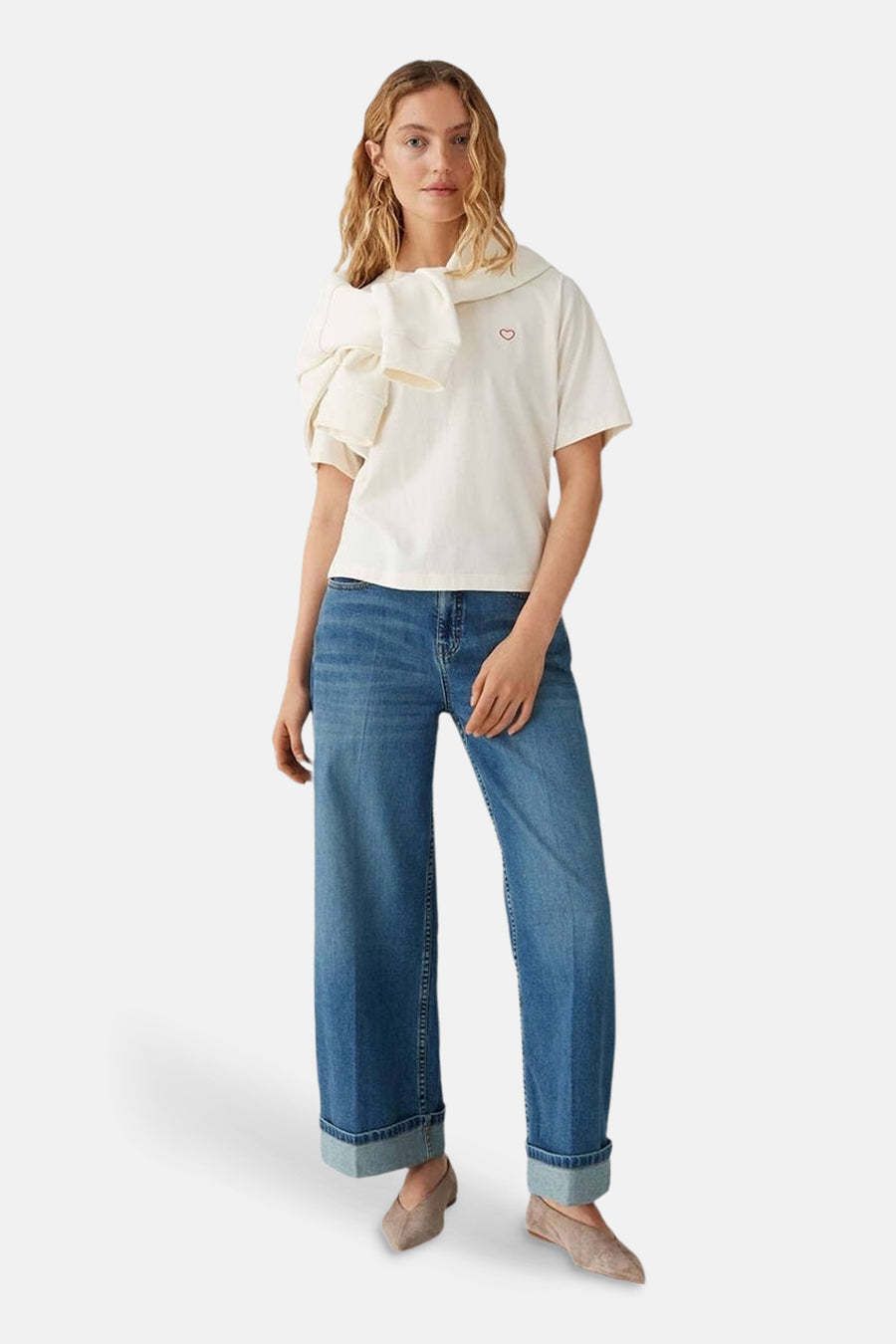 Top uni manches courtes beige d'OPUS, orné d'un cœur rouge, porté avec un foulard blanc et un jean taille haute.
