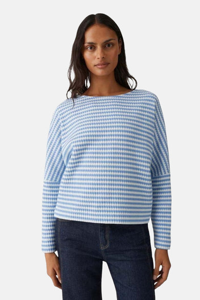 Pull col rond bleu rayé par OPUS, porté avec un jean foncé.
