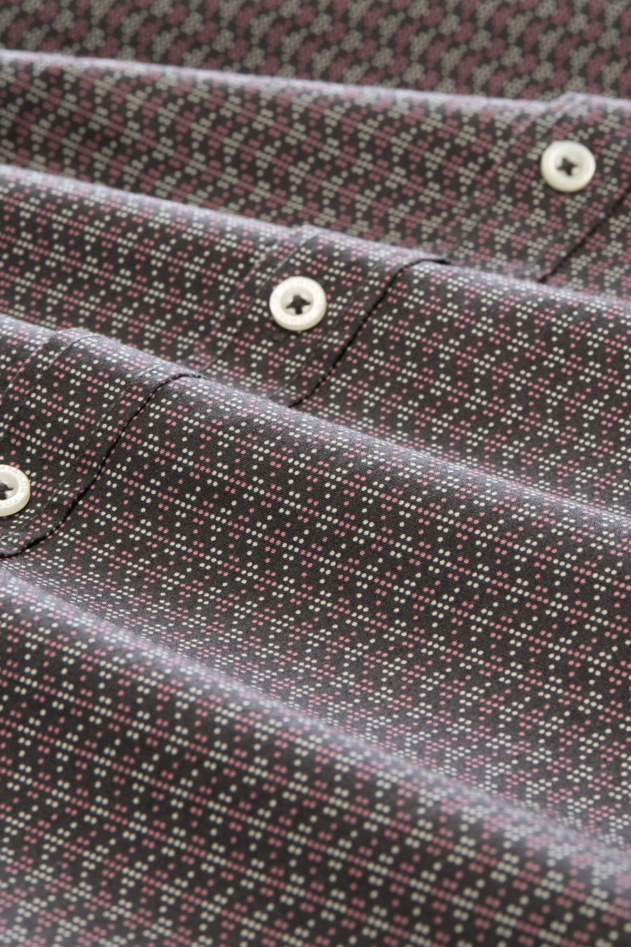 Grey long-sleeve shirt with pink and white geometric pattern, featuring white buttons and a close-up view of the fabric texture.