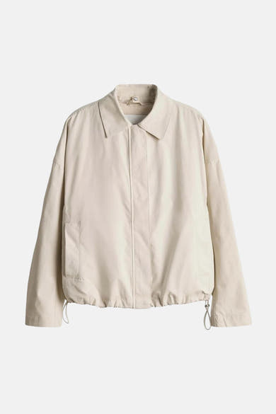 Veste courte beige de OPUS, avec un col classique et une fermeture à bouton.