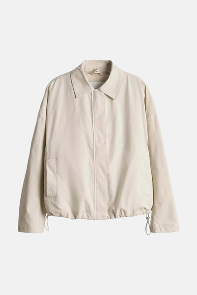 Veste courte beige de OPUS, avec un col classique et une fermeture à bouton.
