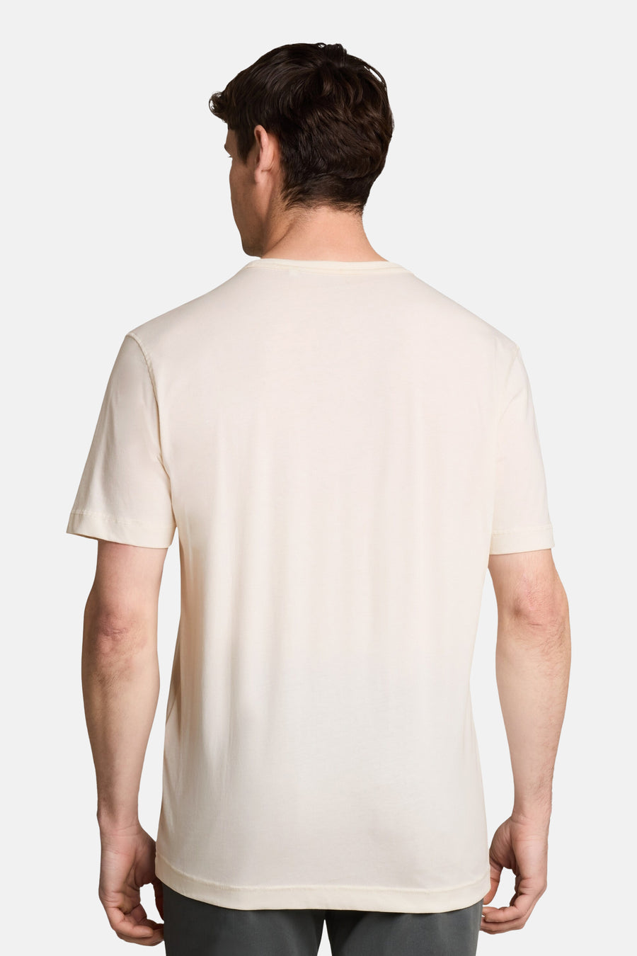 White short-sleeve t-shirt back view, plain cotton fabric, clean fit on model wearing dark pants