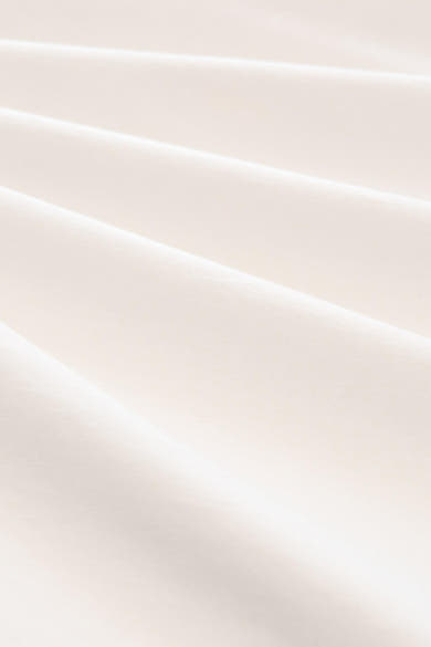 White short-sleeve t-shirt fabric close-up, smooth cotton texture with soft folds and natural lighting.