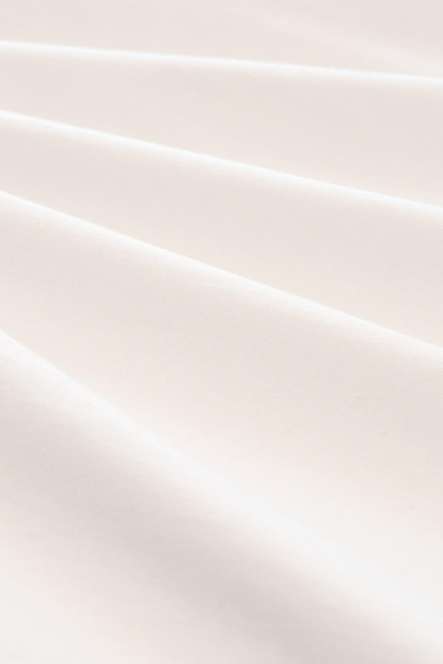 White short-sleeve t-shirt fabric close-up, smooth cotton texture with soft folds and natural lighting.