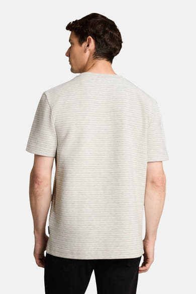White short-sleeve t-shirt with fine horizontal stripes, back view, worn with dark jeans