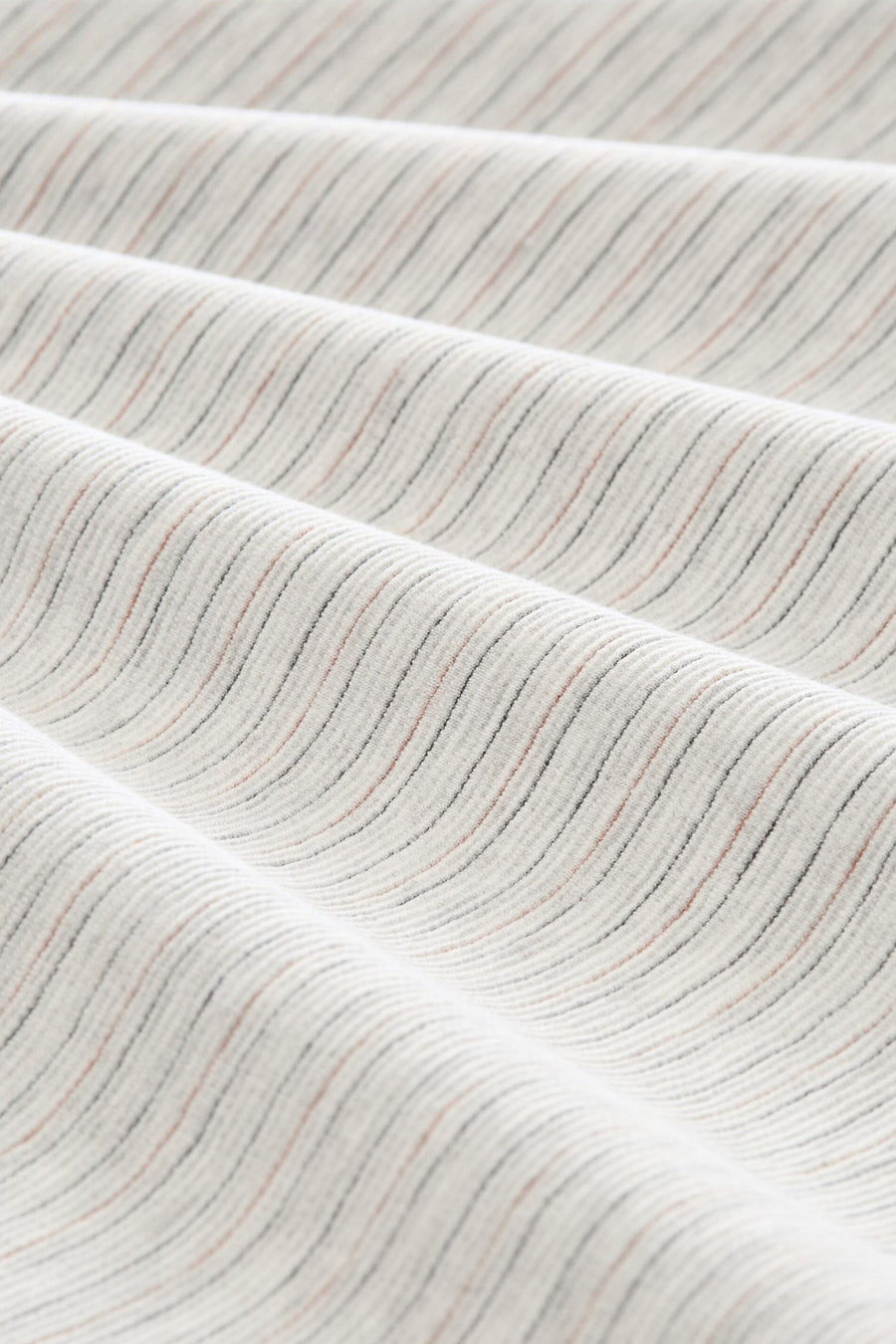 White short-sleeve t-shirt with fine ribbed texture and subtle multicolor stripes, close-up view