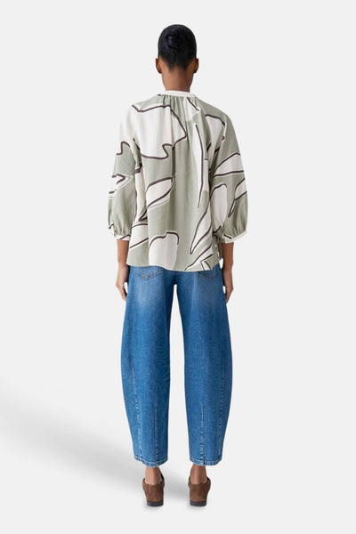 Chemisier 3/4 multicolore par OPUS, avec motif abstrait vert et blanc, porté avec un jean bleu ample.
