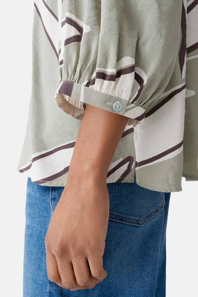 Chemisier manches trois quarts multicolore de OPUS, à motif géométrique et boutonné au niveau des manches, porté avec un jean.
