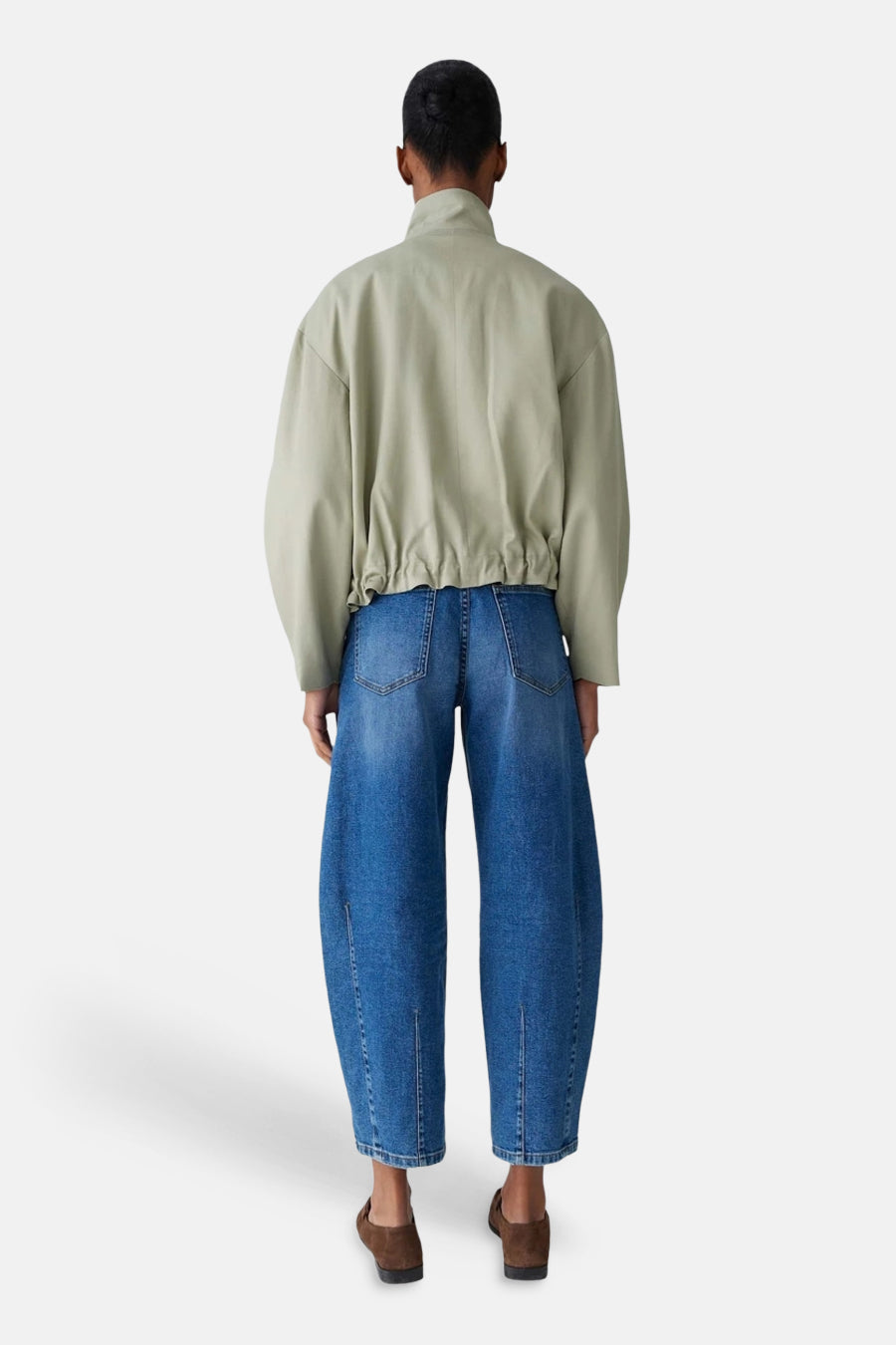 Veste courte vert clair de OPUS, avec une taille élastiquée, portée avec un jean ample bleu.