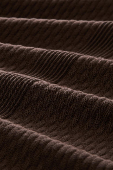 Brown ribbed knit cardigan with textured vertical stitching, close-up view highlighting soft fabric detail