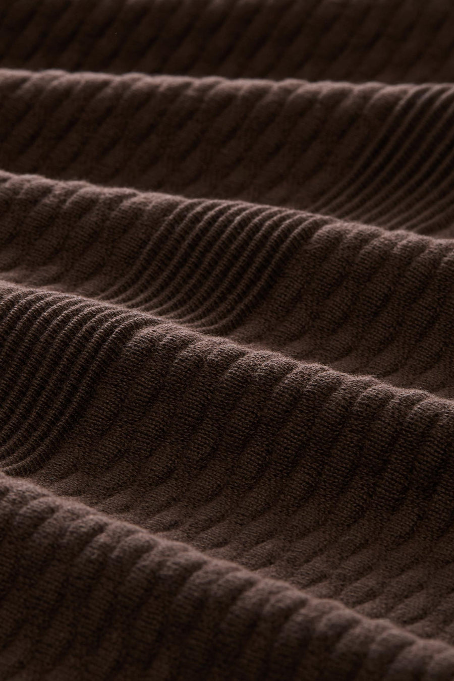 Brown ribbed knit cardigan with textured vertical stitching, close-up view highlighting soft fabric detail