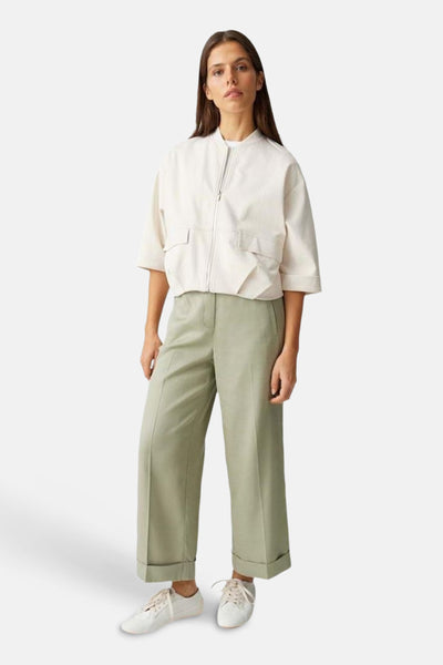 Pantalon de costume vert d'OPUS, coupe droite, porté avec une veste crème et des baskets blanches.
