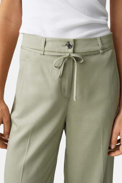 Pantalon de costume vert clair, de OPUS, avec ceinture nouée et poches latérales.
