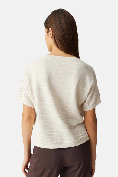 Top uni manches courtes vert de OPUS, avec une texture côtelée, porté avec un pantalon marron.