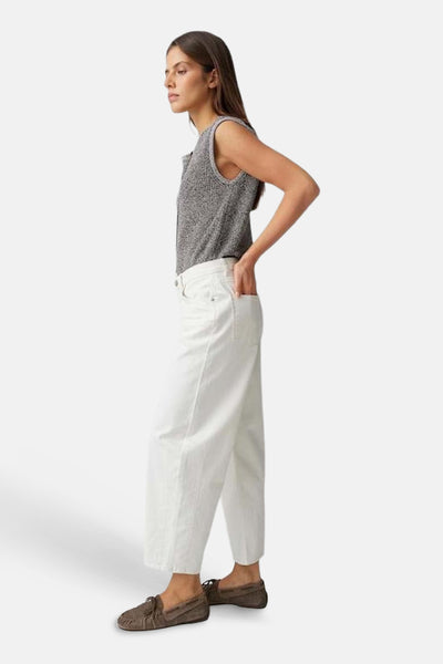 Jean denim blanc cassé de OPUS, coupe large, porté par une femme de profil, les mains dans les poches.