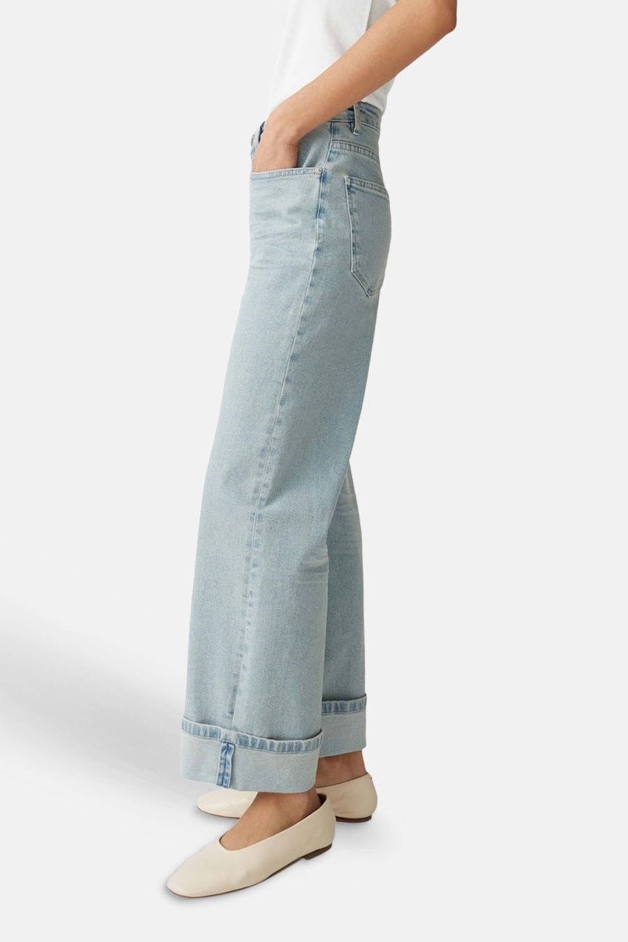 Jeans larges bleu clair en denim de OPUS avec revers aux chevilles, portés avec des chaussures plates claires.